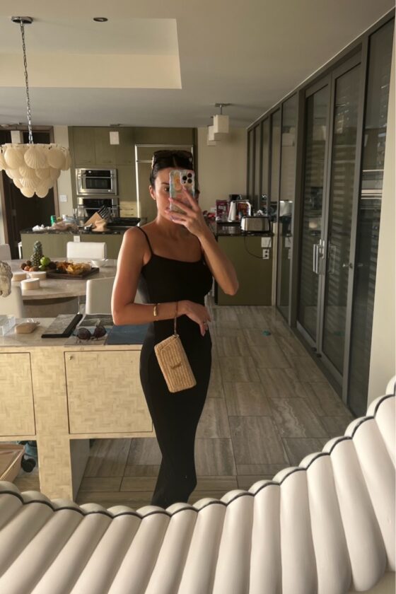 Christine Andrew in a black skims dress on vacation